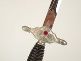 a silver sword with a red stone on top of it