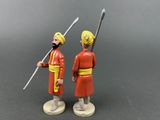 two figurines of two men dressed in red and yellow holding swords