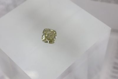 a close up of a yellow diamond sitting on top of a white box