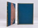 two blue books sitting side by side on a white surface