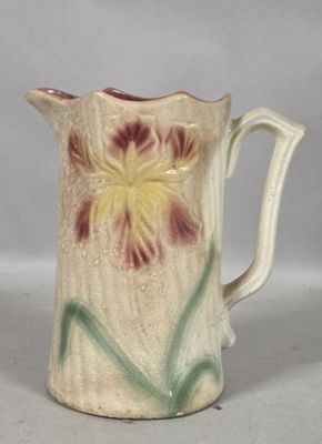 a small pitcher with a flower painted on it