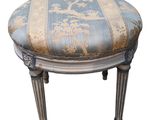 une image représentant un petit tabouret dont l'assise est recouverte d'un tissu bleu et blanc