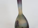 a purple and green vase sitting on a white surface