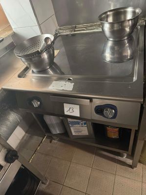 une cuisinière en acier inoxydable sur laquelle est posée une casserole