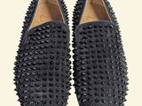 a pair of black spiked shoes on a white background