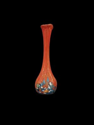 an orange glass vase with blue and white flowers in it on a black background