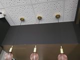 three lights that are hanging from the ceiling above the bar