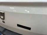 a close up of a white car with a black sticker on it