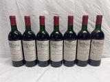 six bouteilles de vin sont alignées dans une rangée