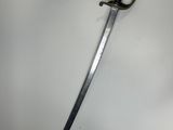 a close up of a sword on a white surface