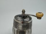a silver salt and pepper shaker on a white table