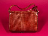 a brown woven purse on a pink background