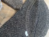 un bonnet tricoté posé sur une table en bois
