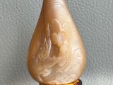 a picture of a small vase on a stand on a white surface