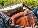a black car with a tan seat and a tan bag on top of it
