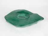 a green glass ashtray on a white background