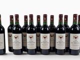 six bottles of wine are lined up in a row on a white surface