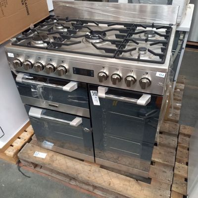 une photo d'une cuisinière posée sur une palette dans un entrepôt