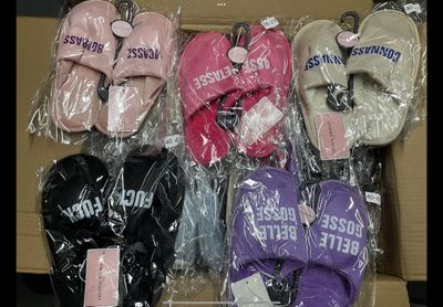 several pairs of pink, purple, and black mittens in a cardboard box