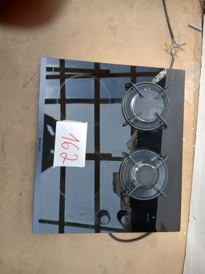 une plaque de cuisson noire à deux feux, sur laquelle est apposée une pancarte
