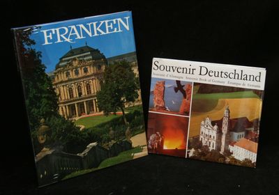 two books on a black surface with a building in the background