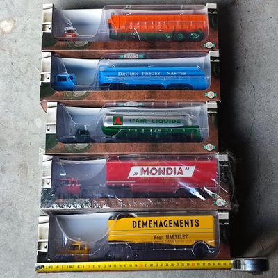 six petits trains miniatures dans une vitrine posée au sol