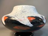 a black and white vase with a red and white design on it