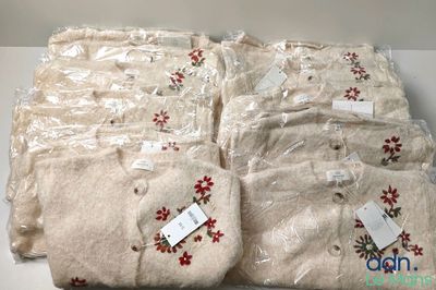 four pairs of white sweaters with red flowers on them are wrapped in plastic