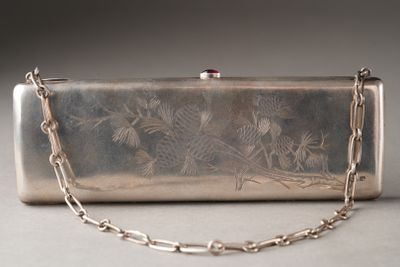 a silver purse with a chain around it on a table