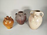 trois vases posés l'un à côté de l'autre sur une table