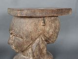 une table en bois sur laquelle est posée une tête sculptée