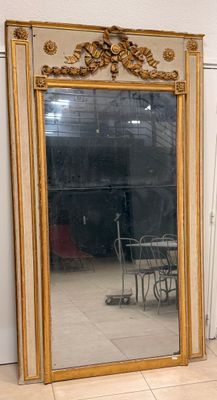 un grand miroir posé par terre à côté d'une chaise