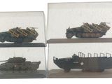 quatre modèles différents de véhicules militaires dans une vitrine