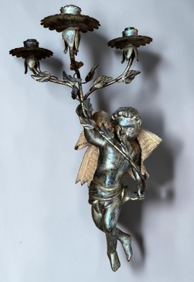 a statue of an angel holding a candelier with birds on it