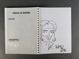 an open notebook with a drawing of a man on it