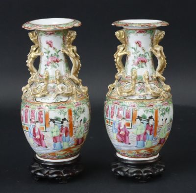 une paire de vases chinois posés sur une surface noire, sur fond noir