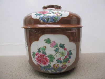 un récipient marron et blanc orné de fleurs