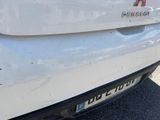 the rear end of a white car with a red dog on it ' s bumper