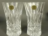 pair of clear glass vases with a gold label on each of them