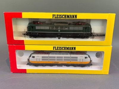 deux boîtes emballées contenant chacune un train miniature, posées sur une surface grise