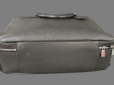 a black suitcase with a handle on a gray background