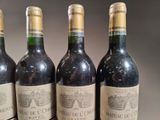 four bottles of wine are lined up on a table