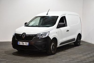 la camionnette blanche est garée dans une pièce au sol en damier