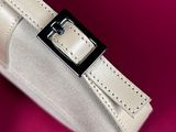 a white purse with a black buckle on a pink surface