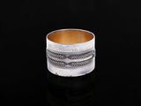 gros plan d'une bague en argent sur une surface noire