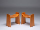 two wooden chairs sitting next to each other on a white surface