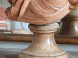 a statue of a woman sitting on top of a marble table