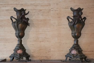 two vases that are sitting on a shelf next to each other