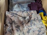 une boîte pleine de vêtements posée sur le sol