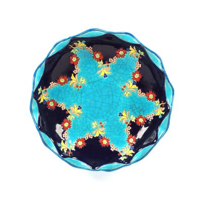 une assiette bleue ornée de fleurs sur un fond blanc